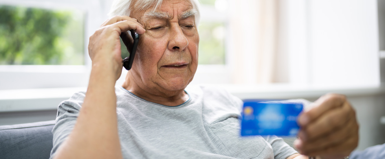 Senior with credit card on phone